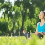 Chica meditando en el campo para mejorar su estilo de vida