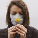Las mujeres con COVID-19 sufren más pérdida del olfato y el gusto. Una mujer huele una flor